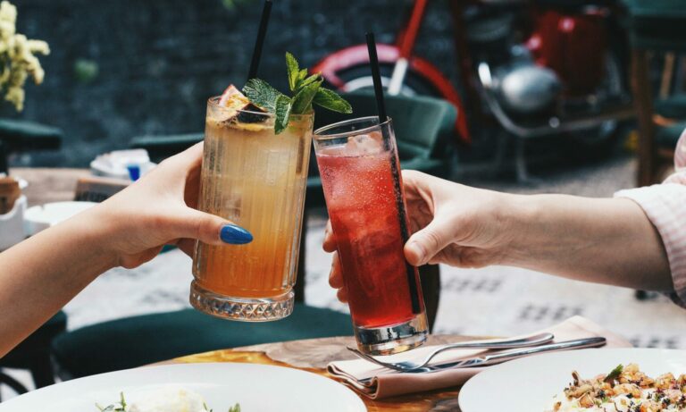 2 personnes trinquant avec 2 cocktails